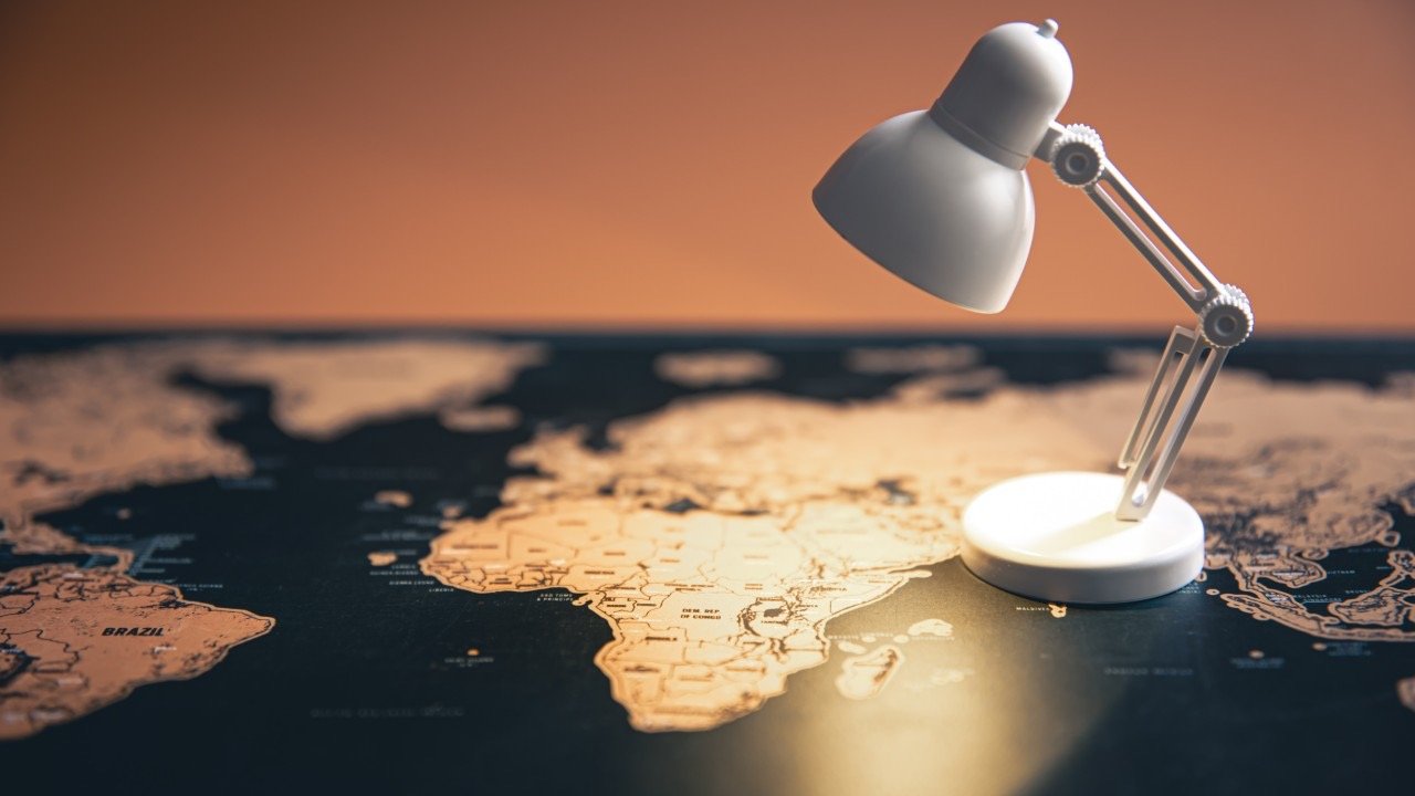 Lámpara iluminando un mapa del mundo, símbolo de alianzas y conexión