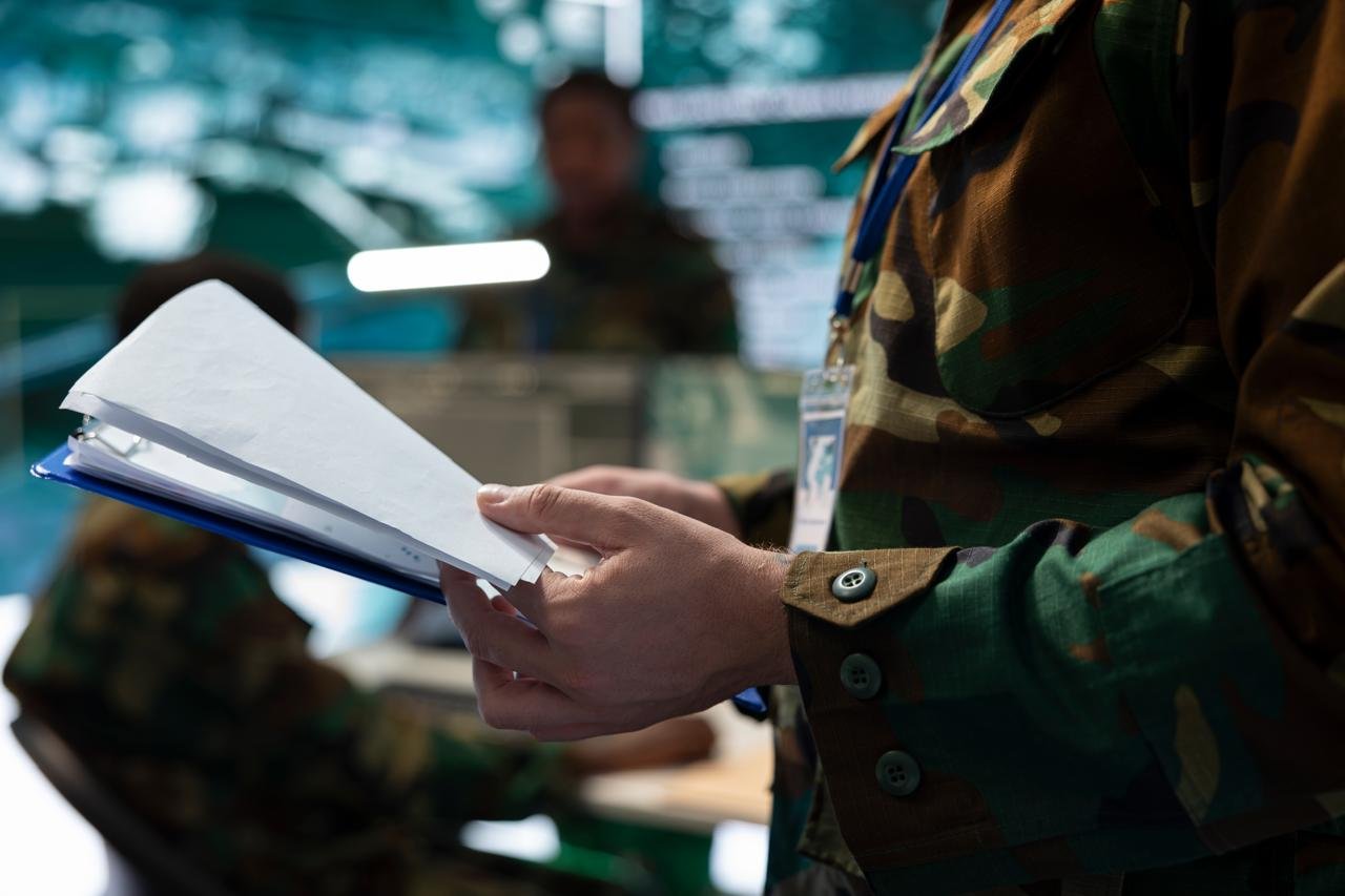 Persona en uniforme revisando documentos de coordinación de seguridad